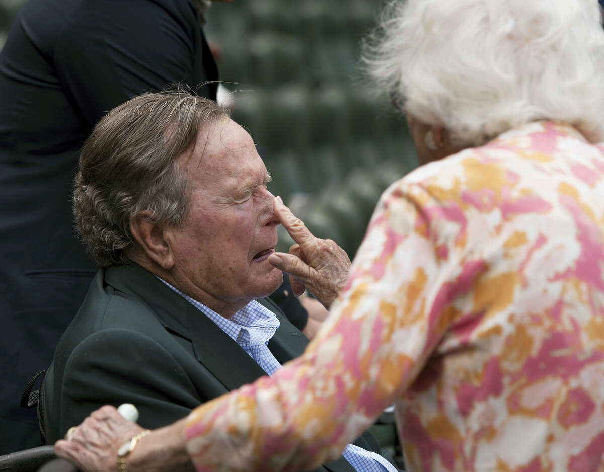 Barbara Bush applies sunscreen to the nose of her husband, former President George H.W. Bush, before the Seattle Mariners take on the Houston Astros in a baseball game in Houston, Texas in 2015.
