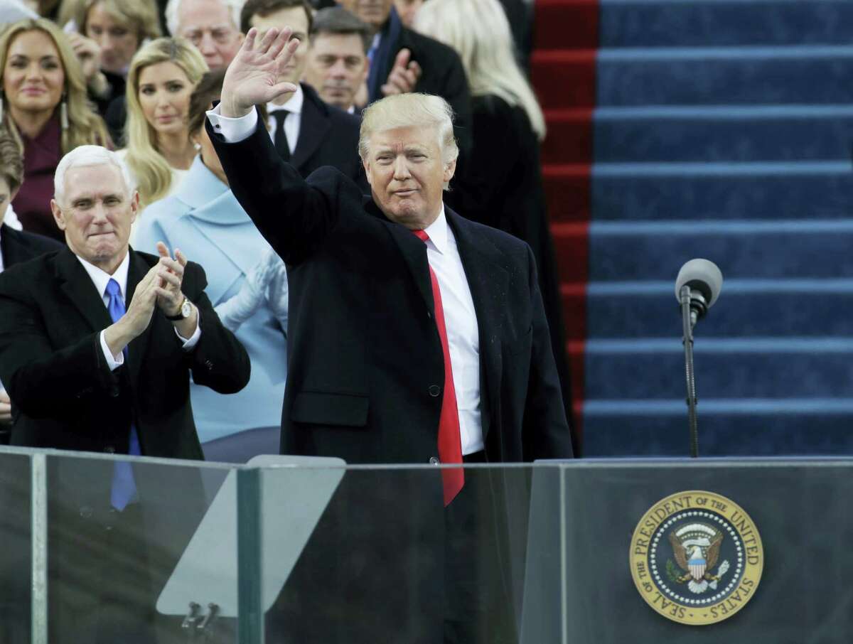 Vice President Mike Pence, left, applauds as President Donald Trump waves after delivering his inaugural address after being sworn in as the 45th president of the United States during the 58th Presidential Inauguration at the U.S. Capitol in Washington on Friday.