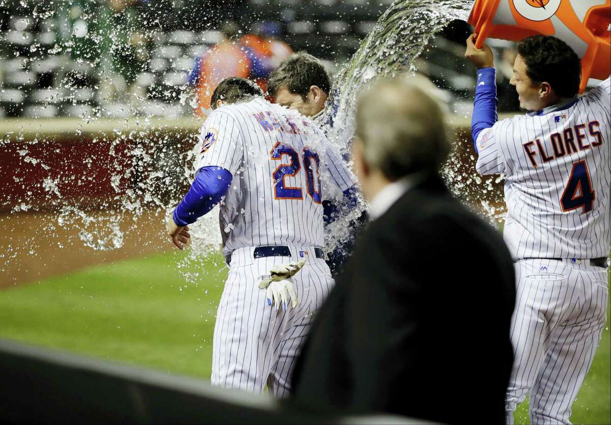 The Mets’ Wilmer Flores (4) dumps a cooler on Neil Walker after Monday’s win.