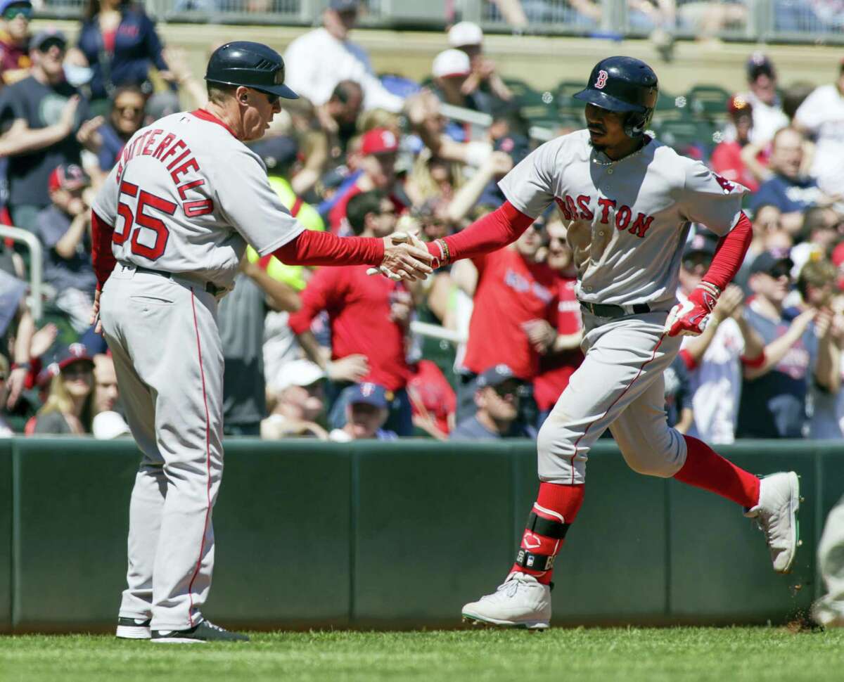 Mookie Betts, right, is congratulated by third base coach Brian Butterfield after hitting a solo home run in the fifth inning Sunday.