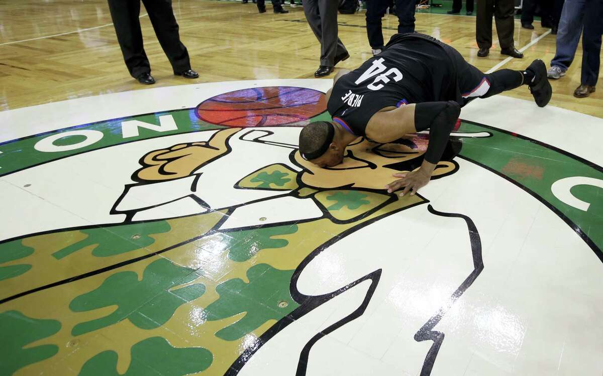 Clippers forward Paul Pierce bends down to kiss the Boston Celtics logo following Sunday’s game in Boston.