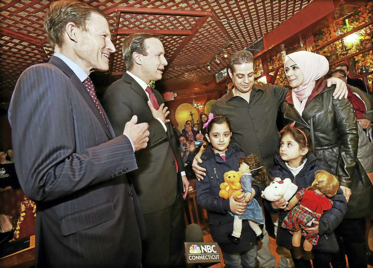 From left, U.S. Sens. Richard Blumenthal and Sen. Chris Murphy welcome Syrian refugees Fadi Kassar, his wife, Razan Ghandour, and their two young daughters, Hanan Kassar, 8, and Layan Kassar, 5, at the Olive Tree Mediterranean Deli in Milford Friday.