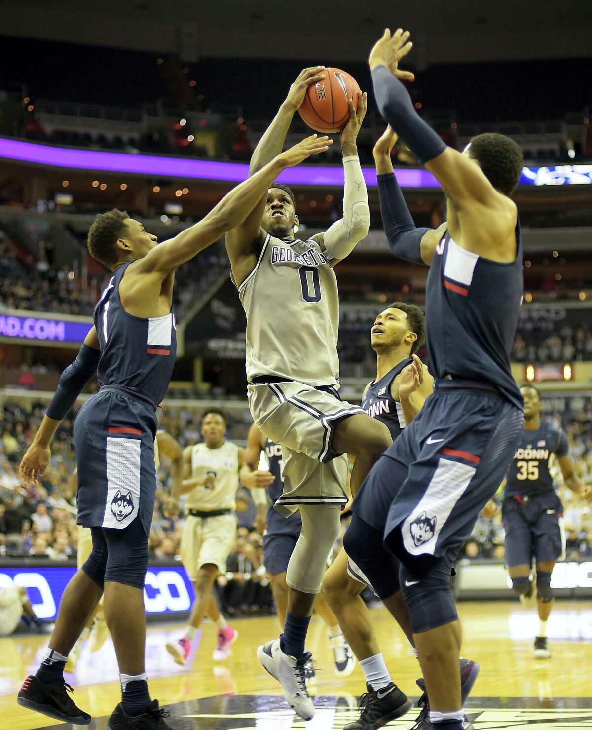 Georgetown’s’ L.J. Peak, center, drives through several UConn defenders during Saturday’s game.
