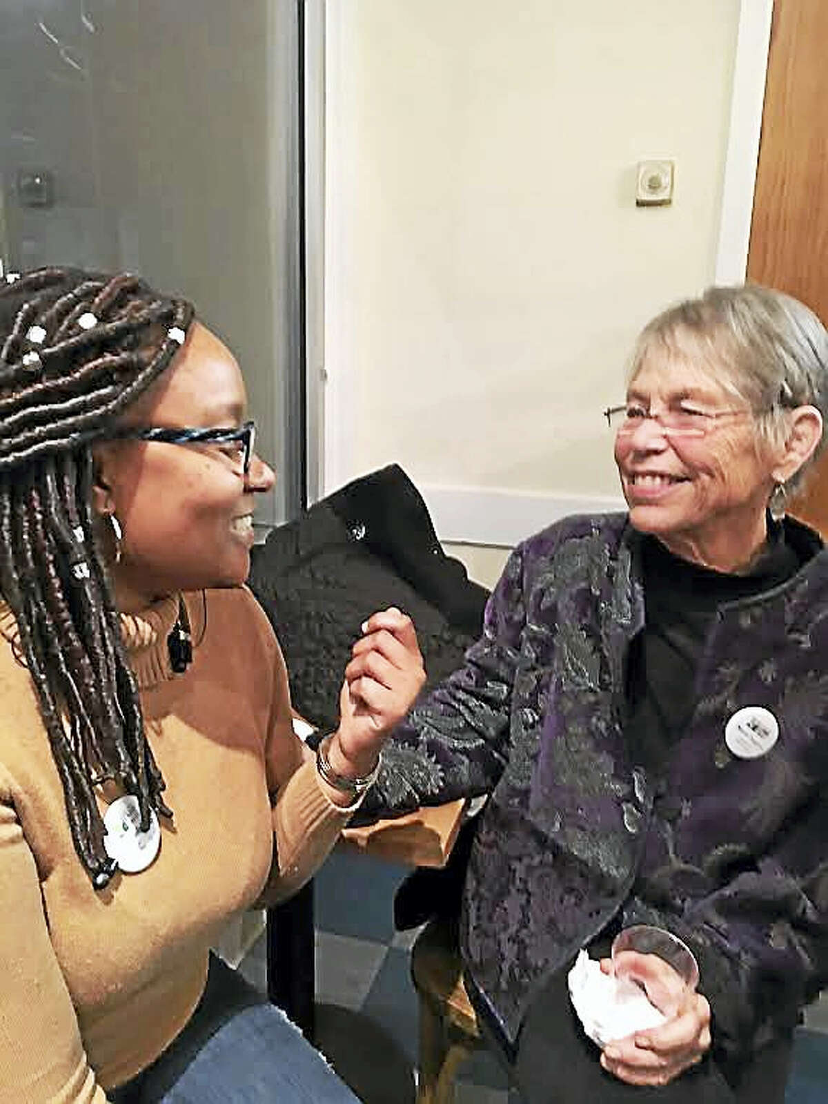 Tyra Pendergrass, left, and Marie Tupper, both members of the New Haven Land Trust board, get to know each other better at a celebration Wednesday marking the partnership with Schooner Inc.