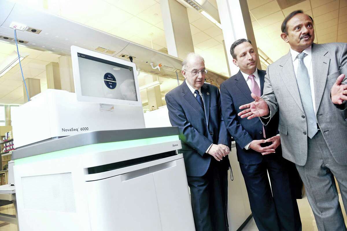 From left, state Senate President Martin Looney, D-New Haven, and state Senate Majority Leader Bob Duff, D-Norwalk, listen to Shrikant Mane, executive director of the Yale Center for Genome Analysis, talk about DNA sequencing next to one of two NovaSeq 6000 Sequencing Systems at the Yale Center for Genome Analysis in West Haven Monday.