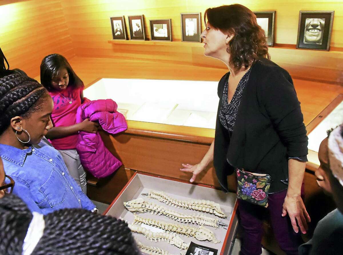 Looking at “discovery drawers” of adult human vertebral columns in the Cushing collection, King-Robinson Magnet School students tour the Cushing Center led by Cushing Center Coordinator Terry Dagradi, right, during a field trip Wednesday in New Haven.