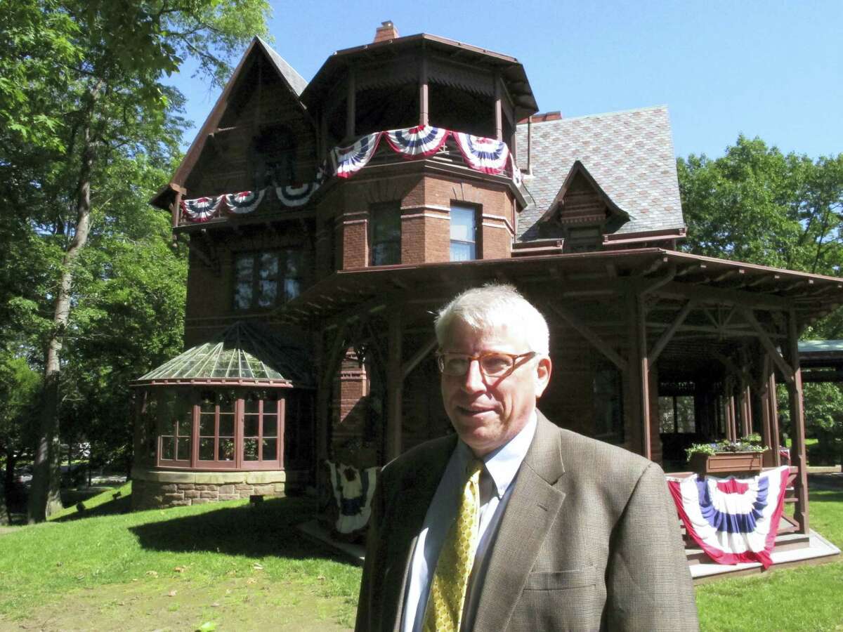 In this Thursday, June 1, 2017 photo, Pieter Roos, the new executive director of the Mark Twain House & Museum, poses outside the landmark in Hartford, Conn. Roos starts his new job July 5 after 18 years as executive director of Newport Restoration Foundation in Rhode Island. (AP Photo/Dave Collins)