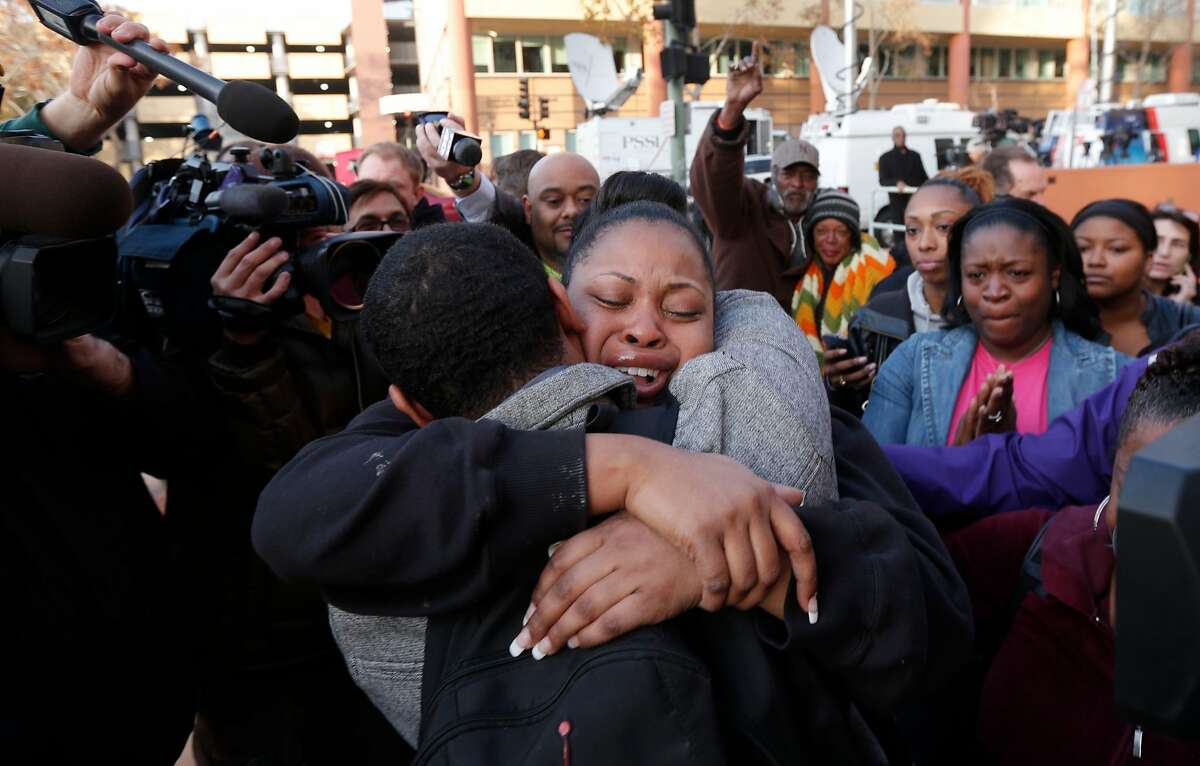 FILE – The mother of Jahi McMath, Nailah Winkfield embraces her brother Omari Sealey, after they stated that the court order to remove Jahi from a ventilator has been extended in this Dec. 30, 2013 file photo. The statement was made by the family to the news media in front of Children's Hospital in Oakland.