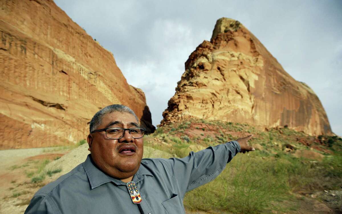 FILE - This June 21, 2016, file photo, Malcolm Lehi, a Ute Mountain Tribal Commissioner points to a rock formation near Blanding, Utah. “We don’t want to forget about our ancestors,” said Lehi. “Through them we speak. That’s the whole concept of protecting and healing this land. They are still here among us as the wind blows.” President Barack Obama designated two national monuments Wednesday, Dec. 28, at sites in Utah and Nevada that have become key flashpoints over use of public land in the U.S. West.