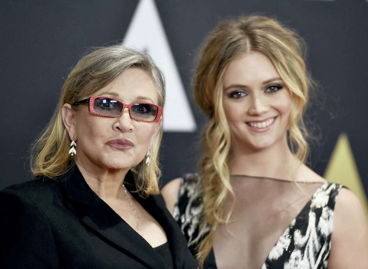 FILE- In this Nov. 14, 2015, file photo, Carrie Fisher, left, and her daughter Billie Catherine Lourd arrive at the Governors Awards at the Dolby Ballroom in Los Angeles. Fisher, a daughter of Hollywood royalty who gained pop-culture fame as Princess Leia in the original “Star Wars” and turned her struggles with addiction and mental illness into wickedly funny books, a hit film and a one-woman stage show, died Tuesday.