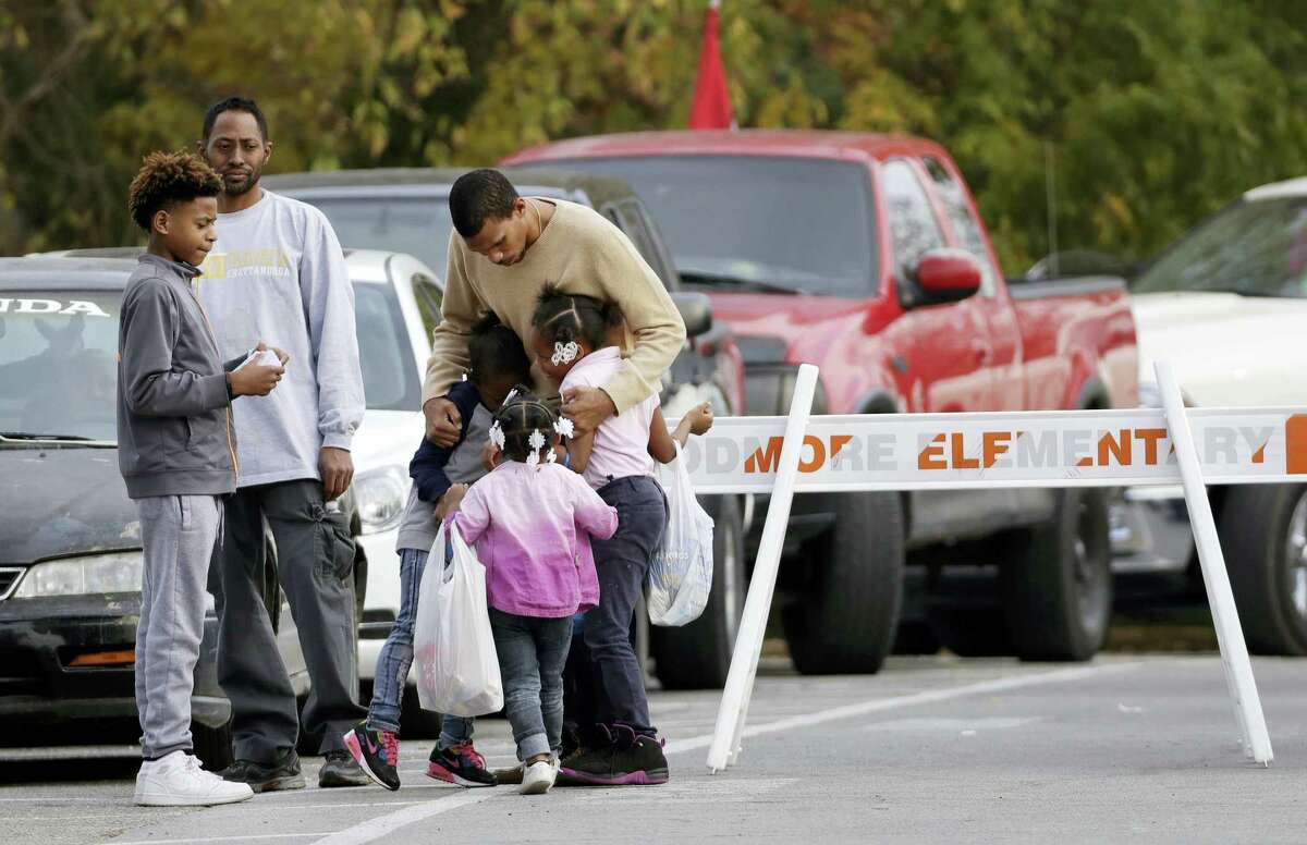 Children get a goodbye hug as students are picked up from Woodmore Elementary School on Tuesday, Nov. 22, 2016, in Chattanooga, Tenn. The school bus driven by Johnthony Walker, 24, crashed while transporting children home from the school Monday, killing at least five students. Walker was arrested Monday and charged with five counts of vehicular homicide including reckless driving and reckless endangerment, police said. (AP Photo/Mark Humphrey)