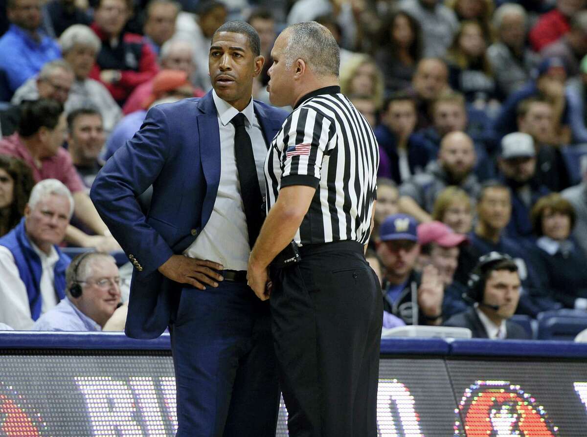 Official Jose Carrion, right, has a word with Connecticut head coach Kevin Ollie in the first half of an NCAA college basketball game, Friday, Nov. 11, 2016, in Storrs, Conn. (AP Photo/Jessica Hill)