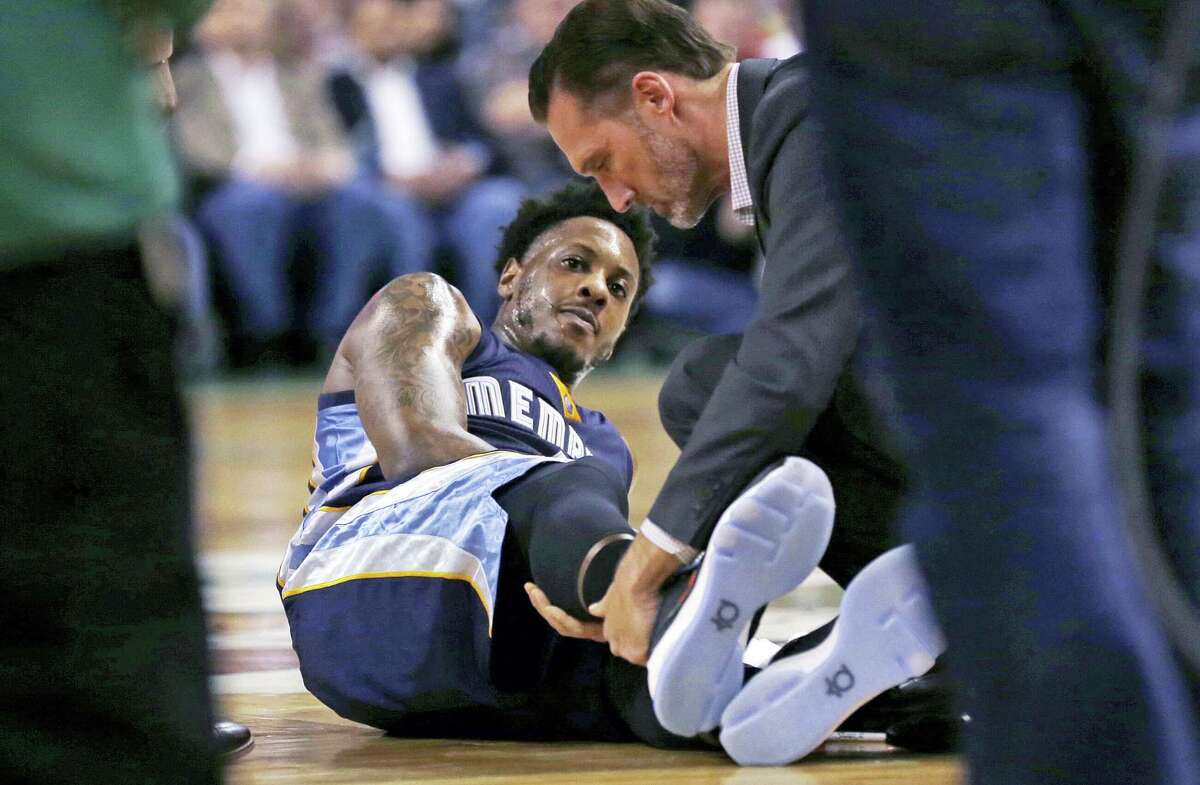 In this March 9, 2016 photo, Memphis Grizzlies guard Mario Chalmers lies on the court as he has his right leg examined during the team’s NBA basketball game against the Boston Celtics in Boston. Chalmers is on target to be cleared for full basketball activity this week, eight months after rupturing his right Achilles. He thinks he could be on an NBA floor again by early December.