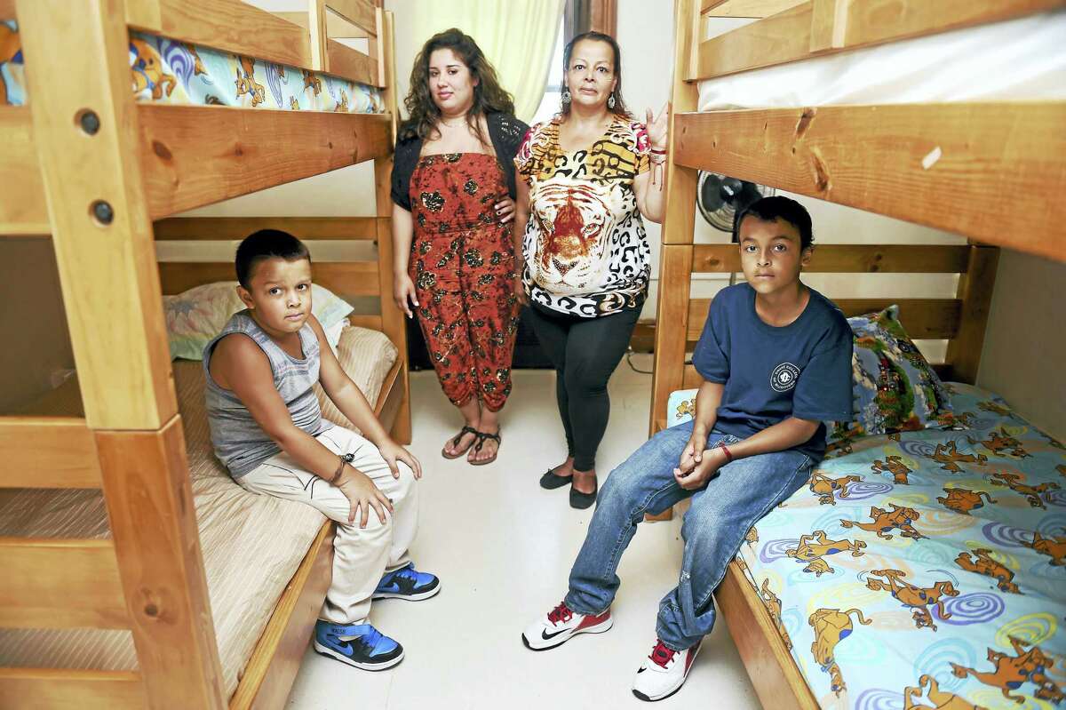 Life Haven case worker Samantha Miranda, center left, with Awilda Gonzalez and her two boys, Xsavier Morales, 7, left, and Isaiah Gonzalez, 11, at the shelter in New Haven on Thursday.