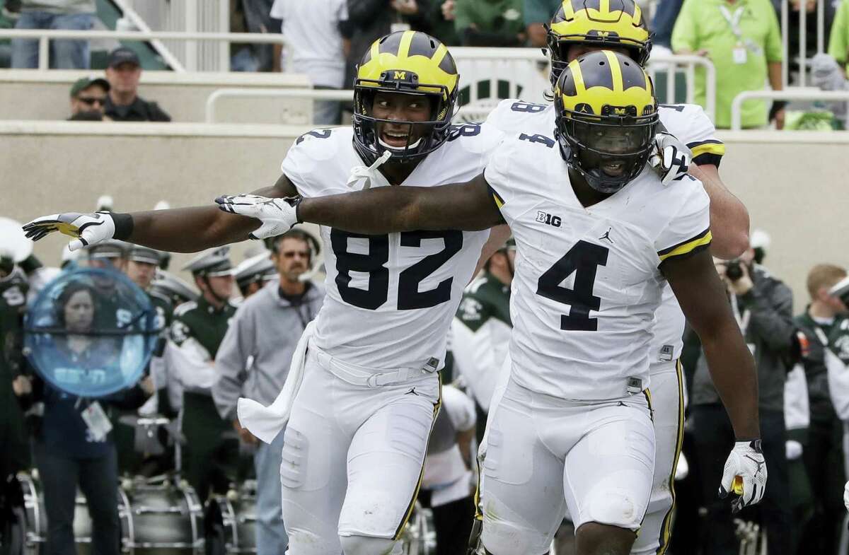 Michigan running back De’Veon Smith (4) is congratulated by wide receiver Amara Darboh (82) after his 5-yard run for a touchdown during the first half on Saturday.
