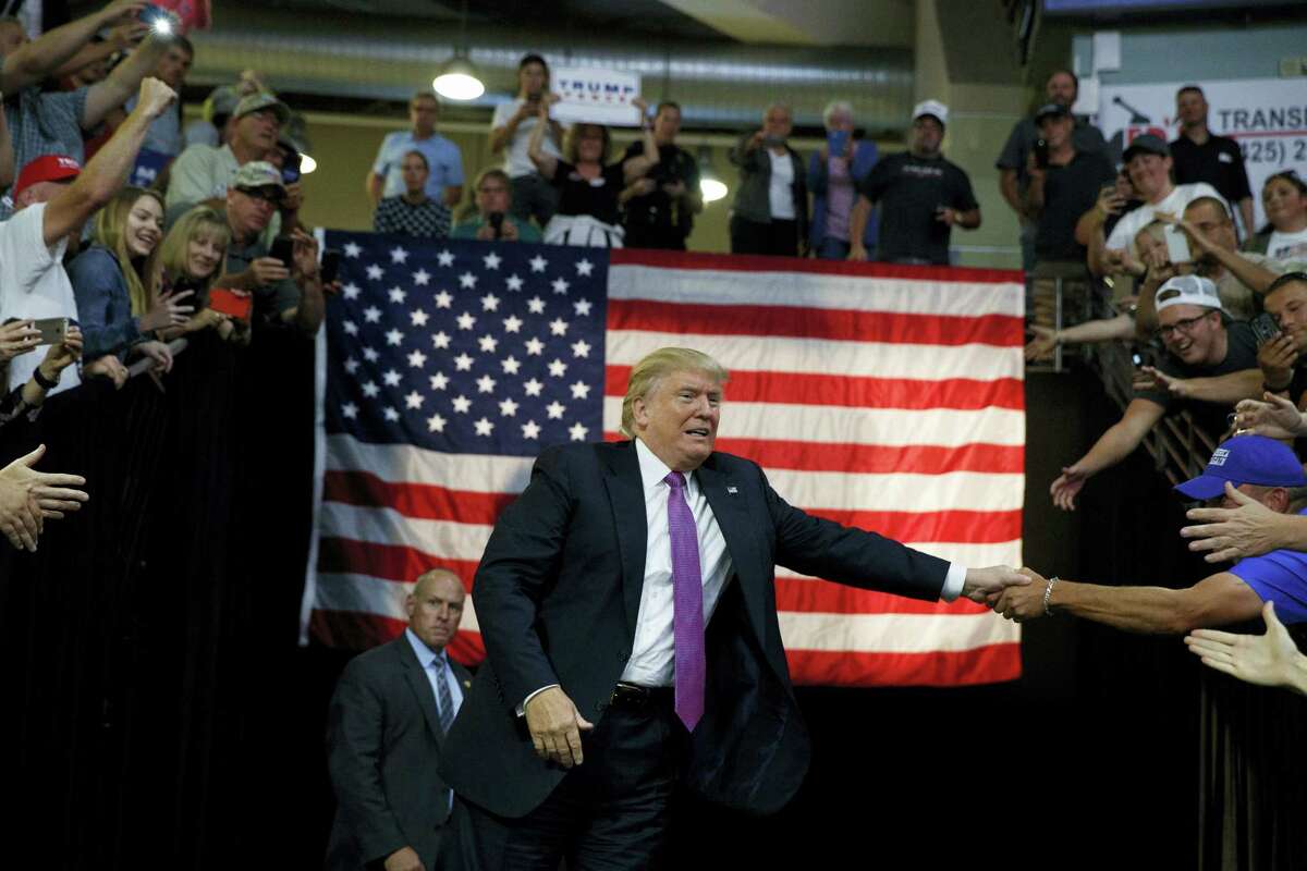 Republican presidential candidate Donald Trump shakes hands as he arrives to a campaign rally at Xfinity Arena of Everett, Tuesday, Aug. 30, 2016, in Everett, Wash.