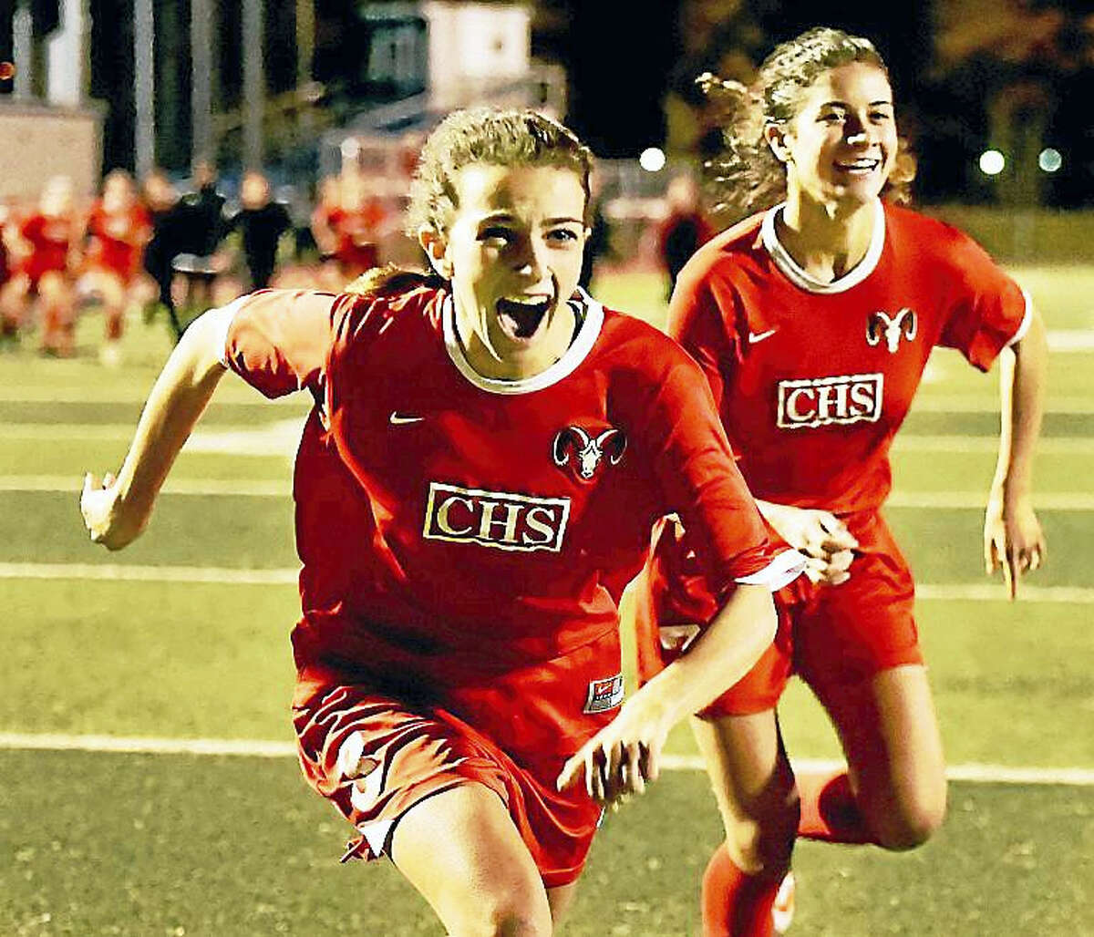 Cheshire senior midfielder Allison Leonetti, left, and senior forward Saige Bingman rush to celebrate with their teammates after defeating Daniel Hand, 5-4, in penalty kicks for the SCC soccer championship Thursday at West Haven High School.