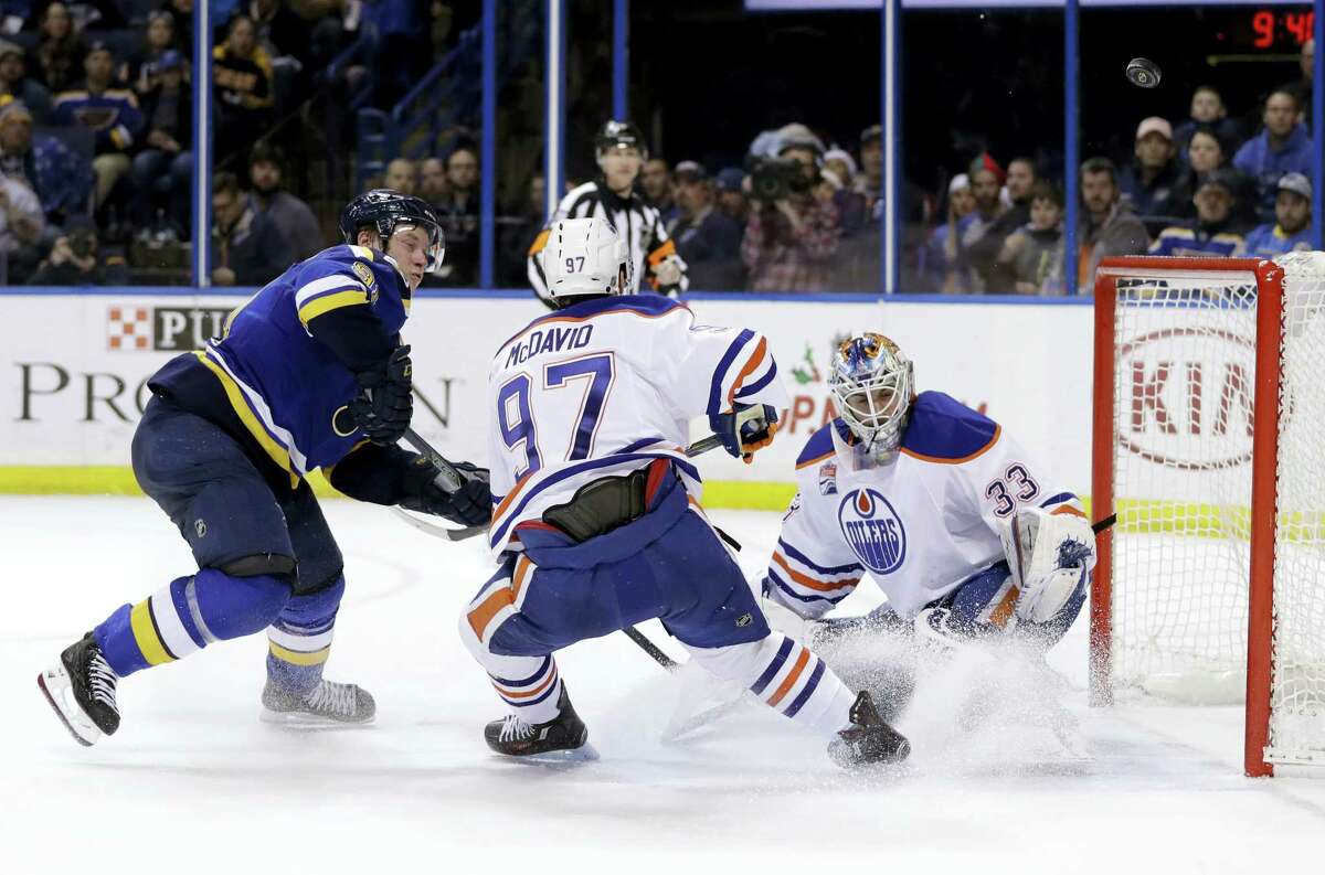 St. Louis Blues right wing Vladimir Tarasenko, of Russia, watches as a puck sails wide past Edmonton Oilers’ Connor McDavid (97) and goalie Cam Talbot (33) during overtime of an NHL hockey game Monday, Dec. 19, 2016 in St. Louis. The Oilers won 3-2 in overtime.