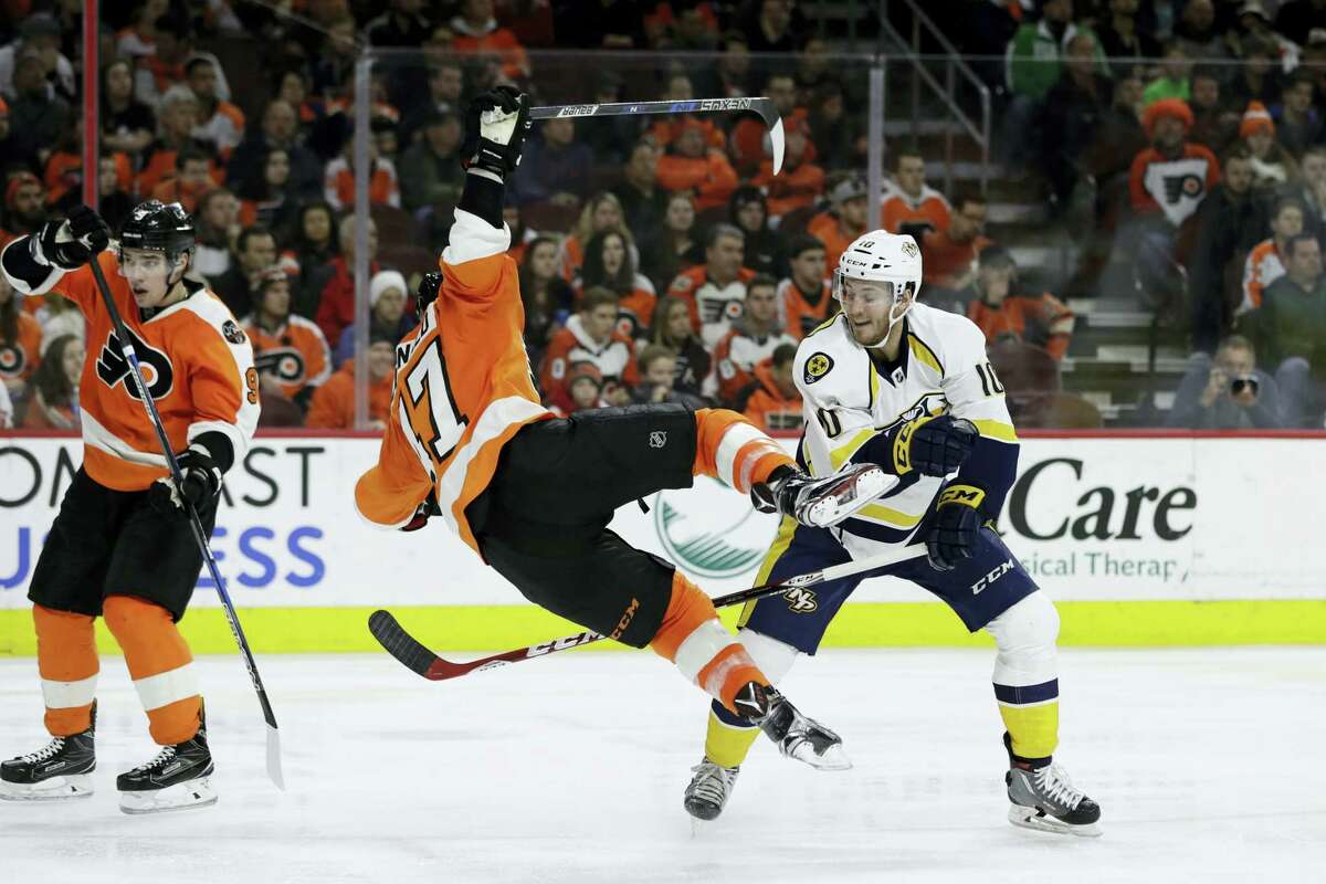 Philadelphia Flyers’ Andrew MacDonald (47) is sent flying after a hit from Nashville Predators’ Colton Sissons (10) during the third period of an NHL hockey game Monday, Dec. 19, 2016 in Philadelphia.
