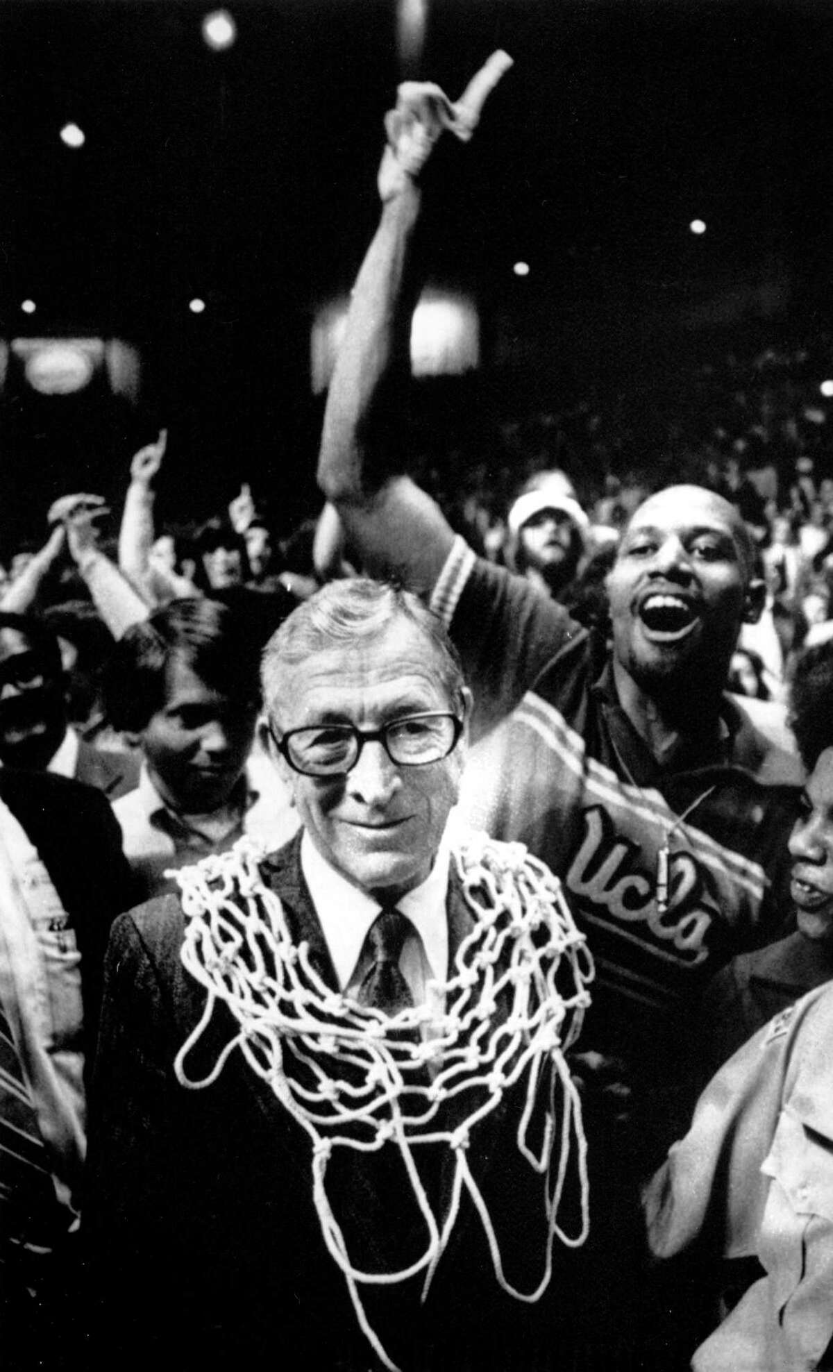 In this March 31, 1975 photo, UCLA basketball coach John Wooden wears a basketball net around his neck after his team won the NCAA basketball championship over Kentucky, 92-85, in San Diego, Calif.