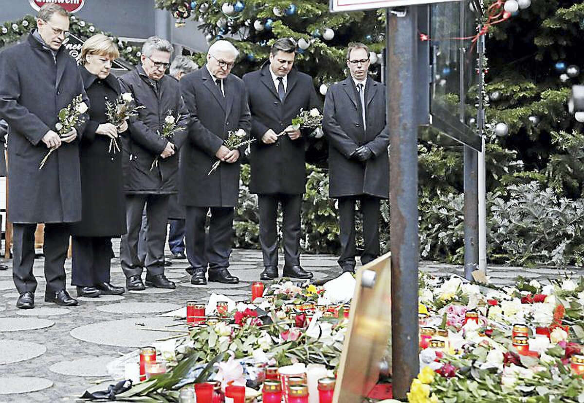 German officials attend a flower ceremony at the Kaiser Wilhelm Memorial Church in Berlin, Germany, Tuesday.