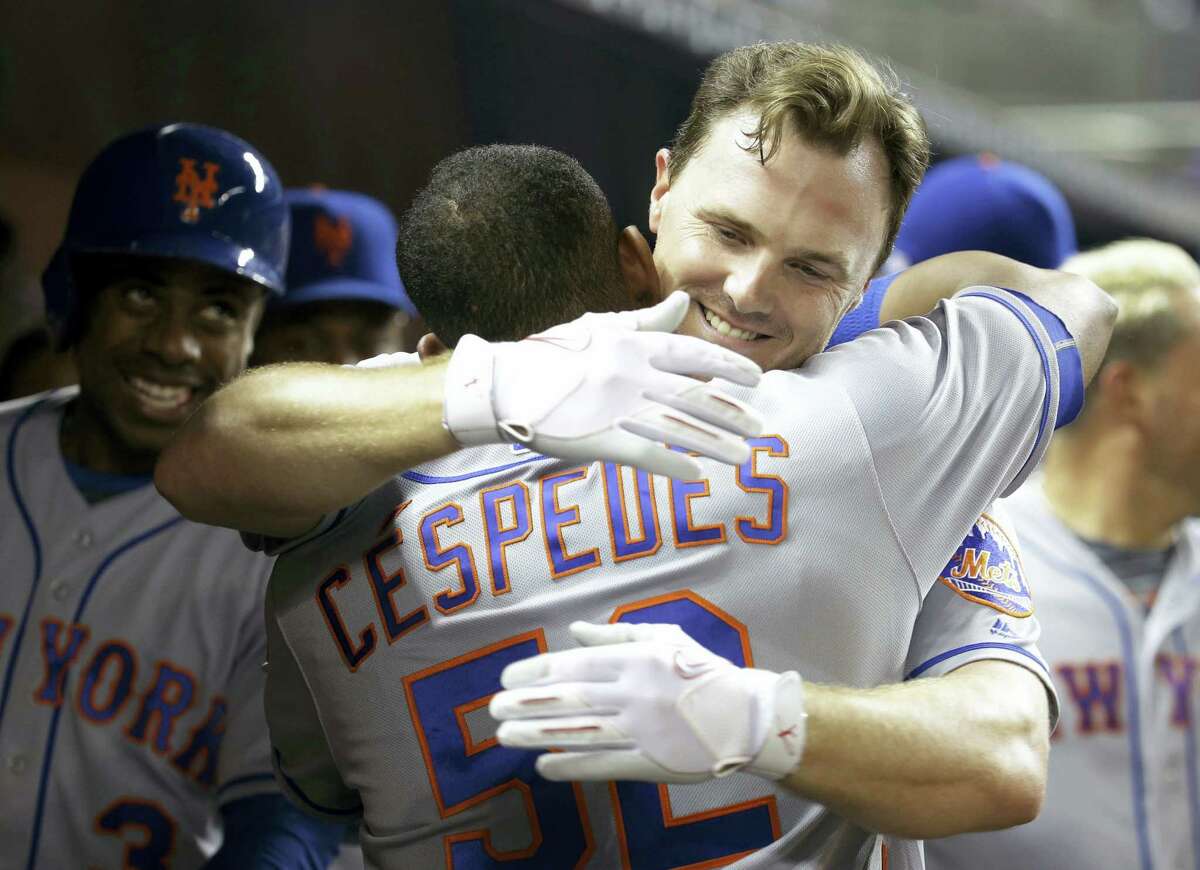New York’s Jay Bruce hugs Yoenis Cespedes (52) after hitting a two-run home run in the fifth inning against the Miami Marlins Wednesday. The Mets won 5-2.