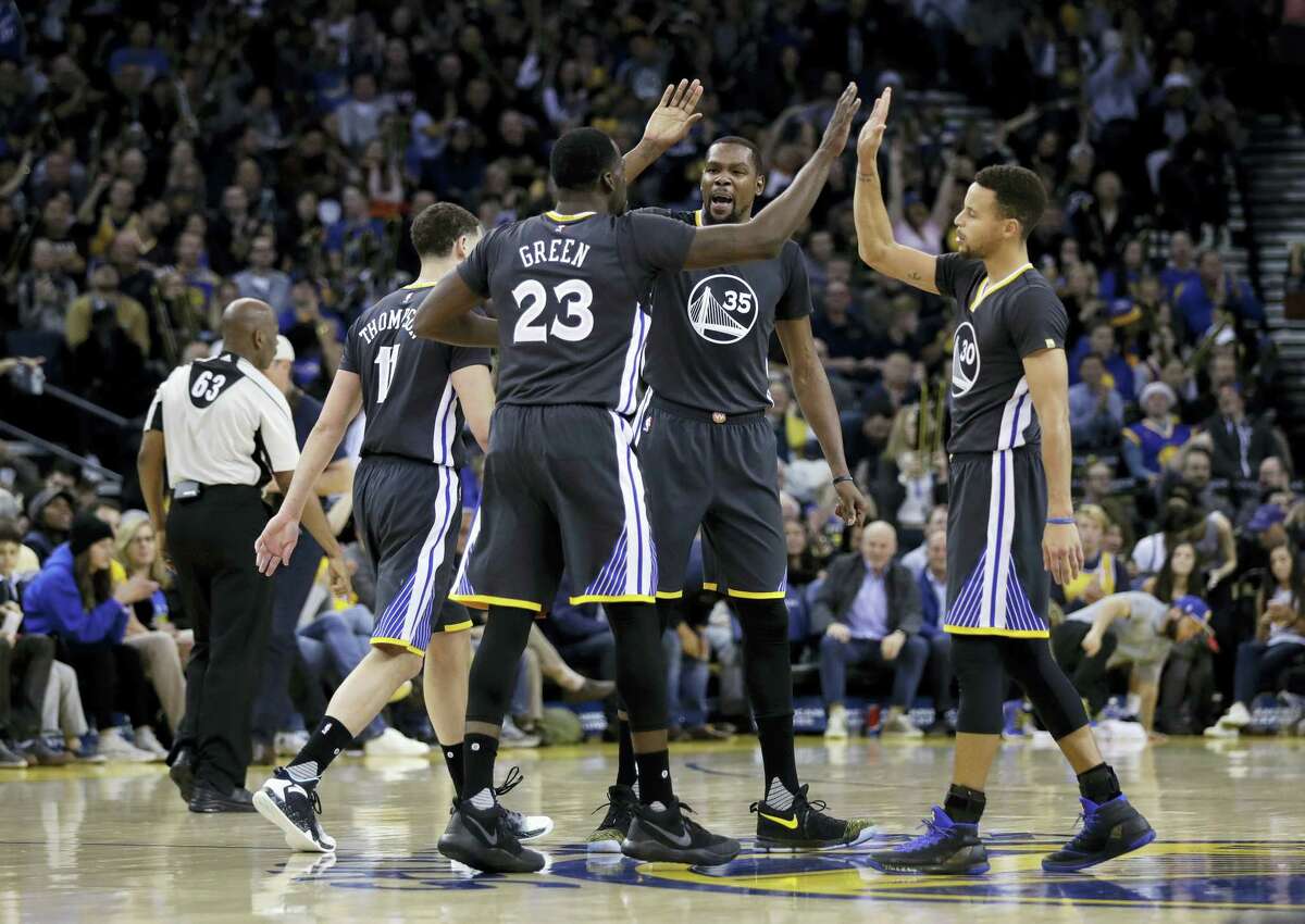 Golden State Warriors’ Draymond Green (23), Kevin Durant (35) and Stephen Curry high five each other during the second half of an NBA basketball game against the Portland Trail Blazers Saturday, Dec. 17, 2016 in Oakland, Calif.