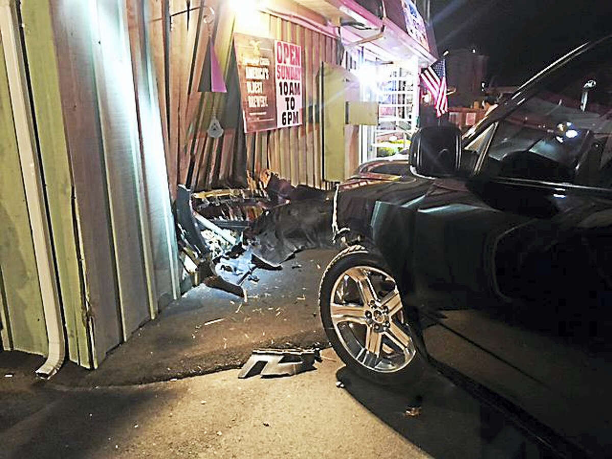Branford police and fire departments respond after a pickup truck driver crashes into a building at 317 East Main St. on Monday, Sept. 26, 2016.
