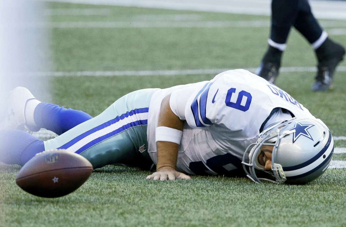 Cowboys quarterback Tony Romo lies on the turf after he went down on a play against the Seahawks during the first half of a preseason game on Thursday in Seattle.