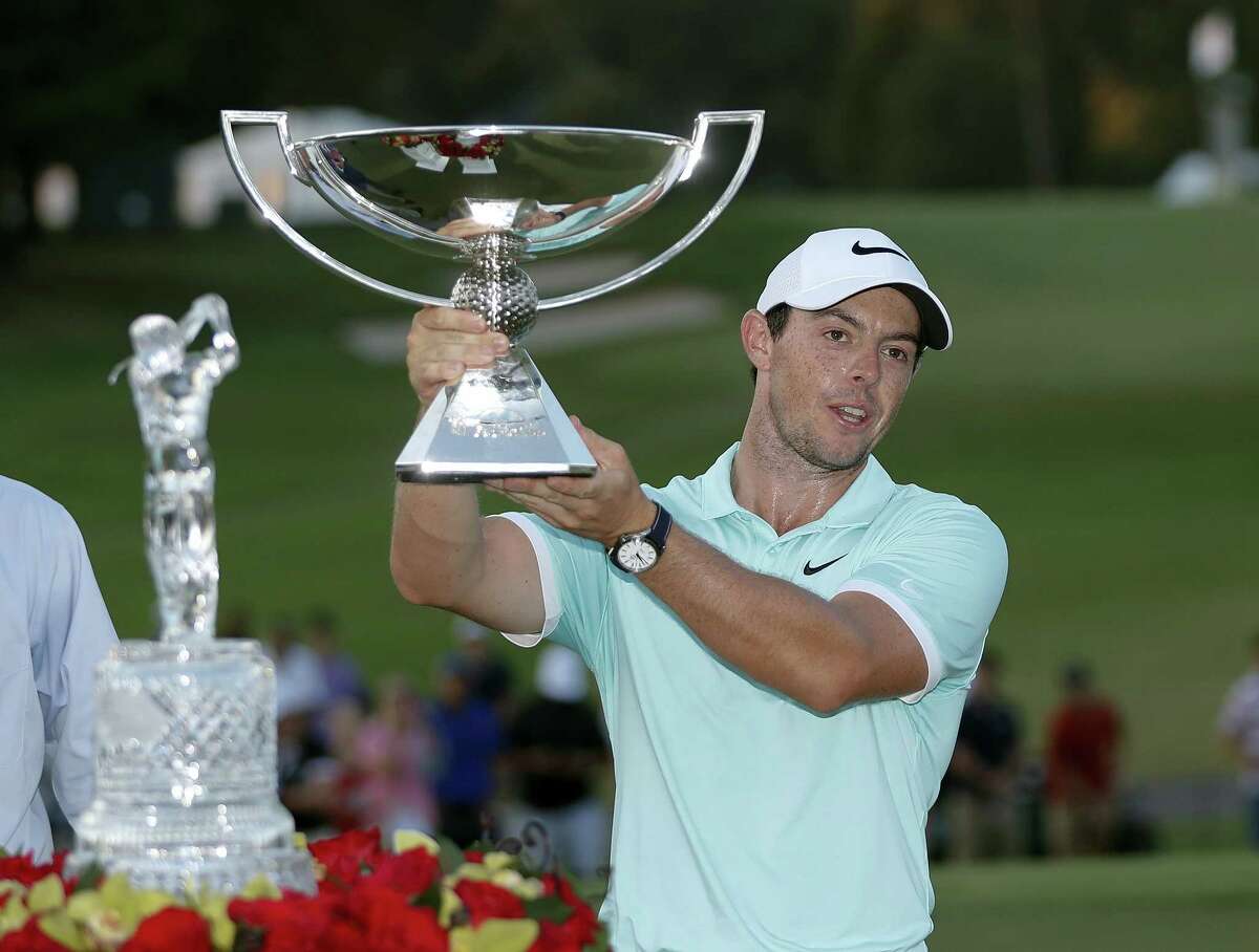 Rory McIlroy poses with the trophies after winning the Tour Championship golf tournament and FedEX Cup at East Lake Golf Club on Sept. 25, 2016 in Atlanta.