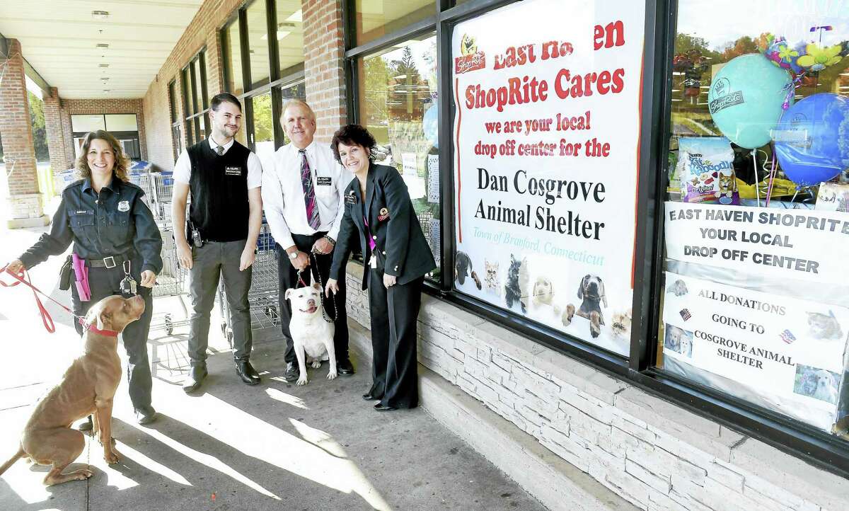 From left, Laura Burban, director of the Dan Cosgrove Animal Shelter; Matthew Gray, grocery manager; Todd Emanuel, store manager; and Dawn Iadarota, customer service manager, are photographed with Hooch, left, and Ruby, center, in front of the East Haven ShopRite, where donations are being collected for the shelter. The two dogs currently are up for adoption, along with many other animals, at the Branford shelter.