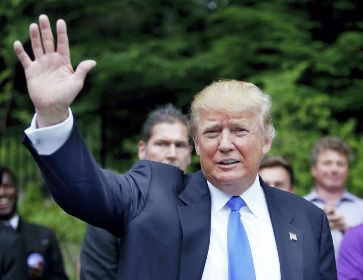 In this June 30, 2015, photo, Republican presidential candidate Donald Trump waves as he arrives at a house party in Bedford, N.H. Hispanic leaders are warning of harm to Republican White House hopes unless the party’s presidential contenders do more to condemn Trump, who’s refusing to apologize for calling Mexican immigrants rapists and drug dealers. (AP Photo/Jim Cole)