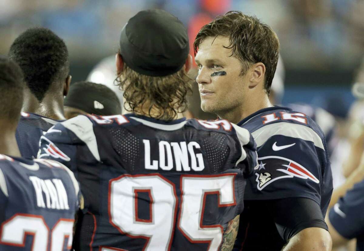 Tom Brady, right, talks with Chris Long, left, on the sidelines during the second half on Friday.