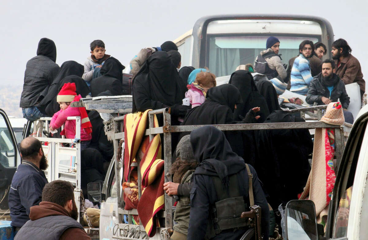 This image released by Aleppo 24, shows residents of eastern Aleppo arriving in western rural Aleppo, Syria, Friday, Dec. 16, 2016, as part of an evacuation deal. The evacuation of eastern Aleppo stalled Friday after an eruption of gunfire, as the Syrian government and rebels threw accusations at each other, raising fears that a peaceful surrender of the opposition enclave could fall apart with thousands of people believed to be still inside. (Aleppo 24 via AP)