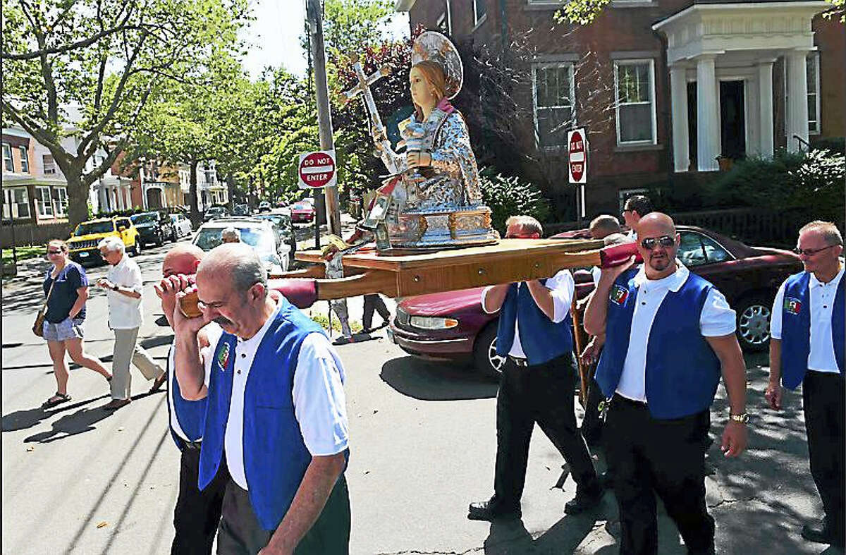 The Santa Maria Maddalena Society in New Haven celebrates its 118th anniversary with its annual Old World procession Sunday as society members carry the statue of St. Maria Madalena, the patron saint of Atrani, Italy, through the streets of Wooster Square.