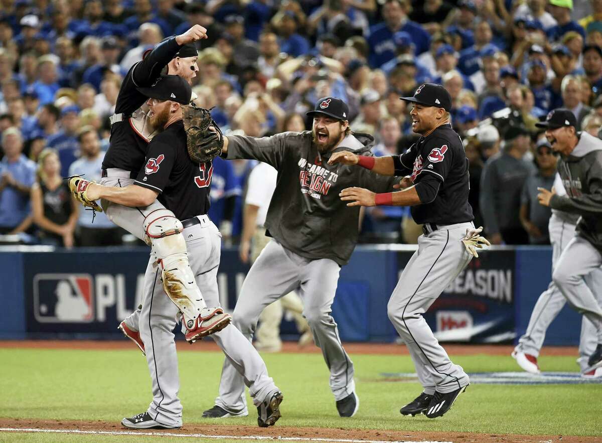 In this Oct. 19, 2016 photo, Cleveland Indians relief pitcher Cody Allen (37), cather Roberto Perez (55) and teammates Andrew Miller and Coco Crisp celebrate the team’s 3-0 victory over the Toronto Blue Jays during Game 5 of the baseball American League Championship Series, in Toronto. Four months after LeBron James and the Cavaliers ended the city’s championship drought at 52 years by winning the NBA title, the Indians are back in the World Series for the first time since 1997.