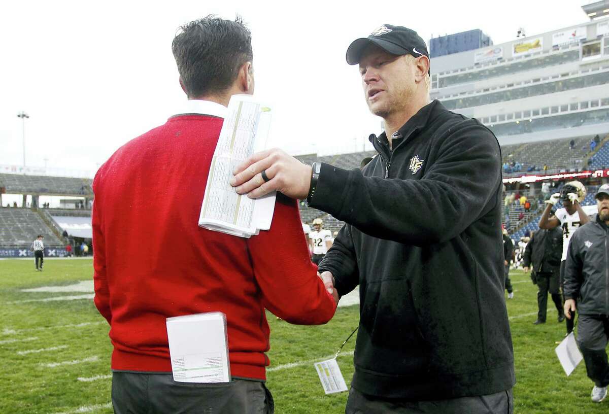 Central Florida head coach Scott Frost, right, shakes hands with UConn head coach Bob Diaco following Central Florida’s victory last Saturday at Rentschler Field,