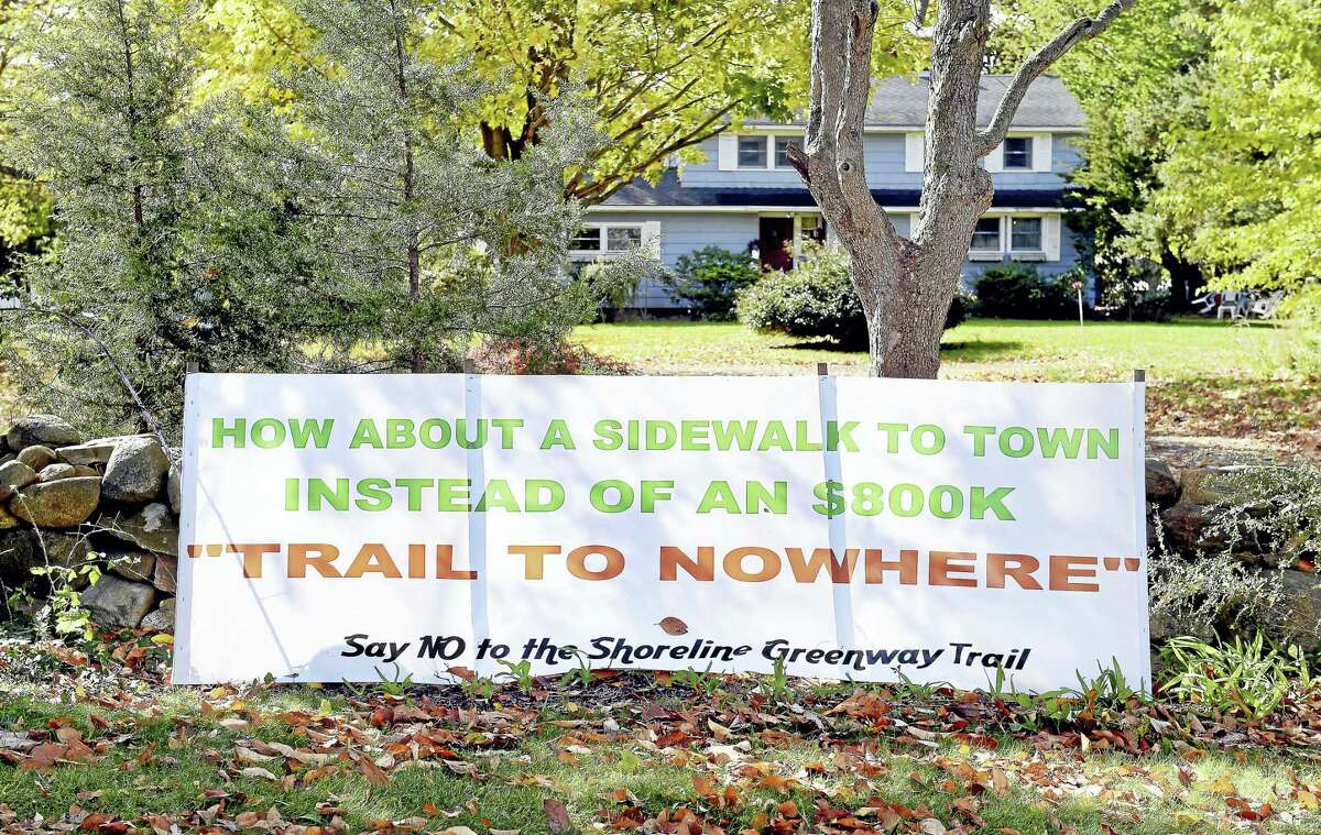 A banner protesting the Shoreline Greenway Trail is posted along Route 1 in Guilford where a proposed section of the trail would pass.