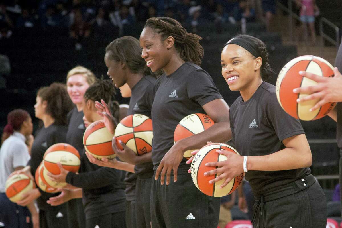 Mmembers of the New York Liberty basketball team await the start of a game against the Atlanta Dream, in New York earlier this month wearing plain black warm-up shirts.