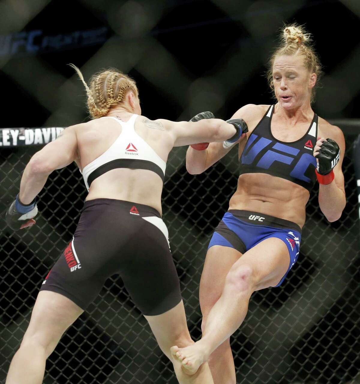 Holly Holm, right, tries to avoid a punch from Valentina Shevchenko during women’s bantamweight mixed martial arts bout in Chicago on Saturday.