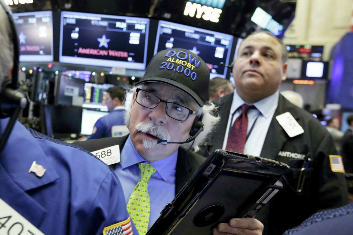 Trader Peter Tuchman wears his “Dow Almost 20,000” cap as he works on the floor of the New York Stock Exchange Thursday.