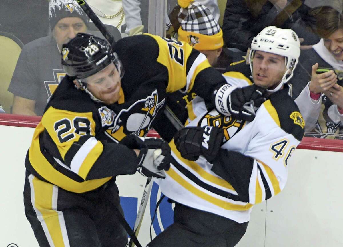 Pittsburgh Penguins defenseman Ian Cole (28) checks Boston Bruins center David Krejci (46) during the first period Wednesday in Pittsburgh. The Penguins won in overtime.