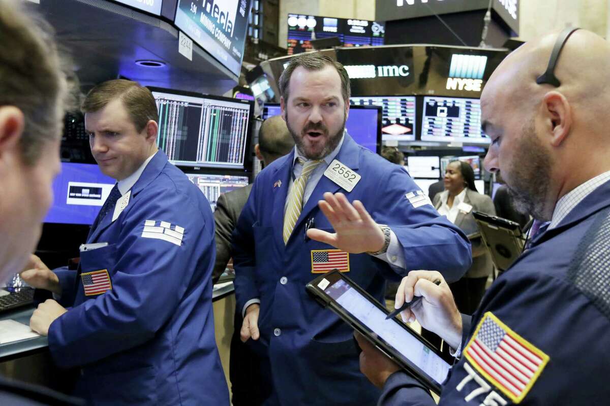Specialist Charles Boeddinghaus, center, works with traders on the floor of the New York Stock Exchange Monday.