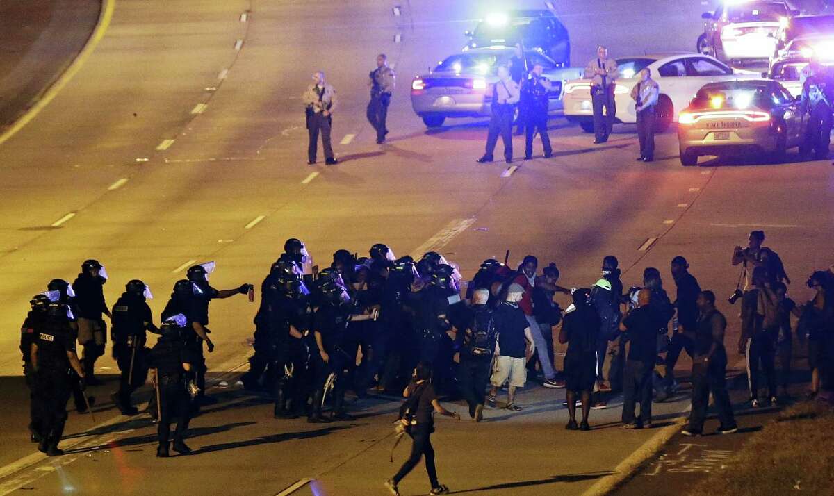 Police confront protesters blocking I-277 during a third night of unrest following Tuesday’s police shooting of Keith Lamont Scott in Charlotte, N.C., Thursday, Sept. 22, 2016. (AP Photo/Gerry Broome)