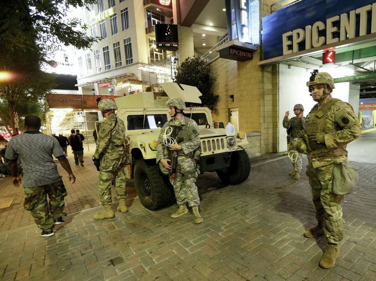 National Guardsman stand on the street in downtown Charlotte, N.C. on Thursday, Sept. 22, 2016. Charlotte police refused under mounting pressure Thursday to release video that could resolve wildly different accounts of the shooting of a black man, as the National Guard arrived to try to head off a third night of violence in this city on edge. (AP Photo/Gerry Broome)