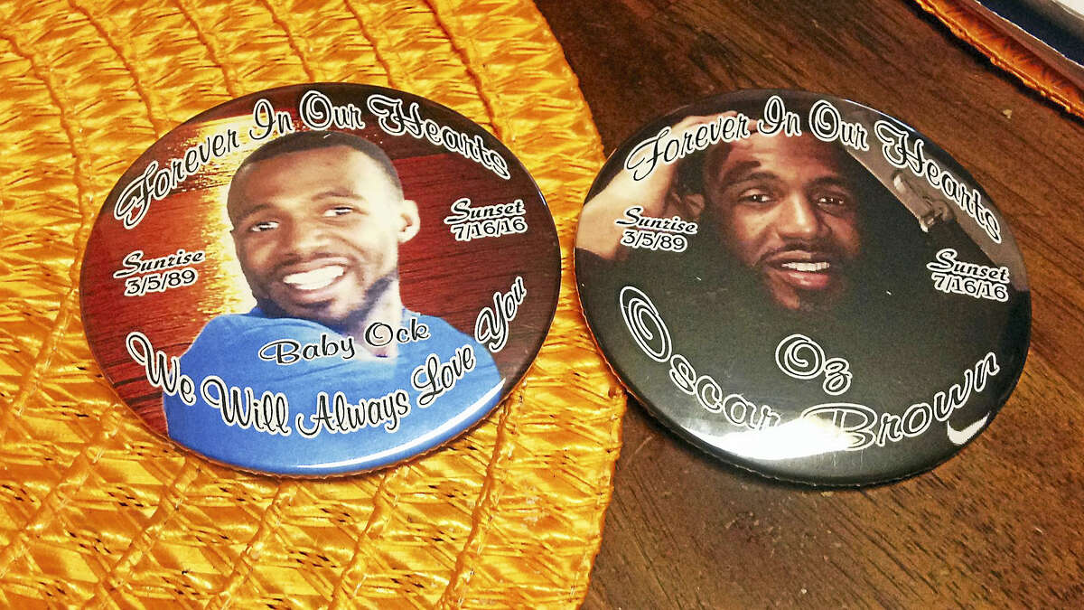 Tanya Williams-Richardson looks at buttons depicting her late son, Oscar Brown.