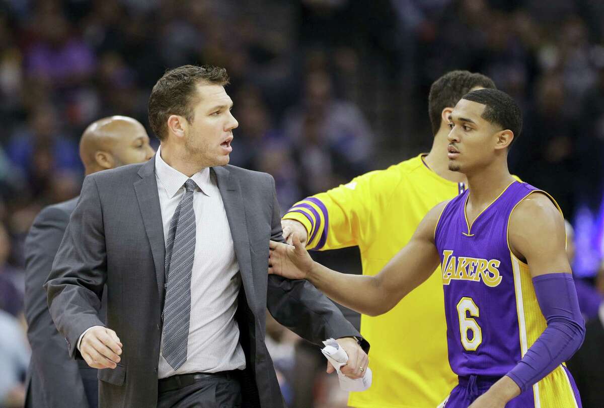 Los Angeles Lakers guard Jordan Clarkson, right, tries to guide Lakers head coach Luke Walton, left, to the locker room after he was ejected when he received two technical fouls during the first quarter of an NBA basketball game against the Sacramento Kings Dec. 12, 2016 in Sacramento, Calif.