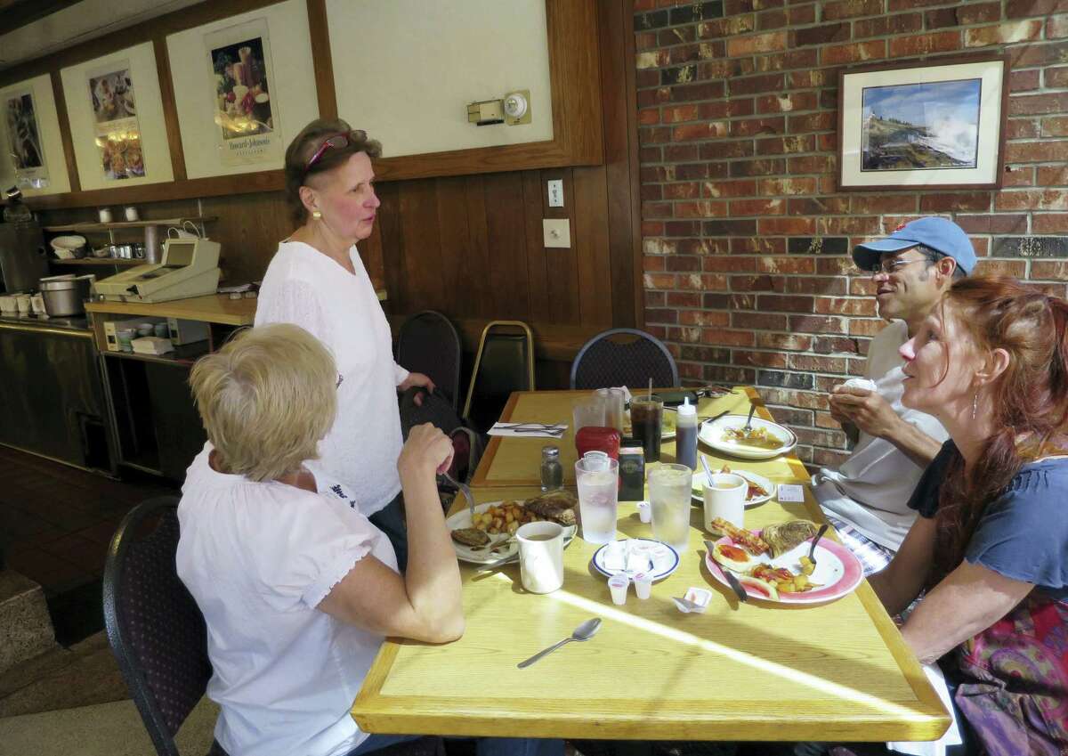 Kathe Jewett, 68, a waitress at Howard Johnson’s in Bangor, Maine since it opened in 1966, speaks to patrons, from left, Brenda Astbury, Christopher Leek and Kelly Gill, at the restaurant, Tuesday, Aug. 23, 2016. One of the last two Howard Johnson restaurants will close Sept. 6, 2016, taking with it the fried clam strips, ice cream _ and a slice of roadside Americana.