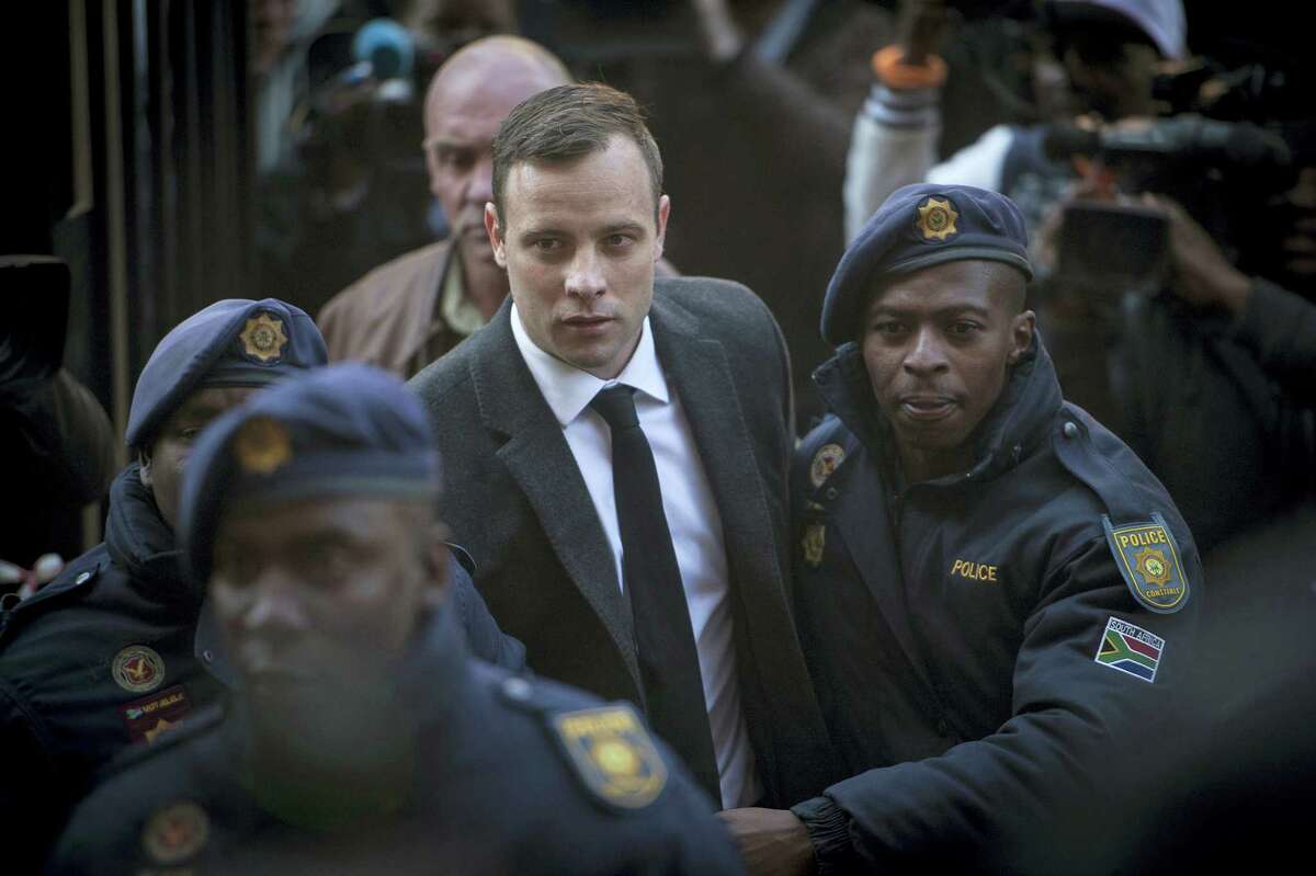 In this July 6 2016 photo, Oscar Pistorius, center, arrives at the High Court in Pretoria, South Africa where he was sentenced to six years for the the killing of his girlfriend Reeve Steenkamp. The National Prosecuting Authority says it is going to appeal the jail sentence, stating that it was “shockingly too lenient”.