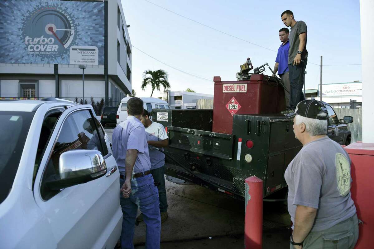 Department of Education employees fill a generator with diesel in San Juan, Puerto Rico, Thursday, Sept. 22, 2016, after a massive blackout hit Puerto Rico Wednesday afternoon, leaving at least 1.5 million people without power overnight and into the following day.